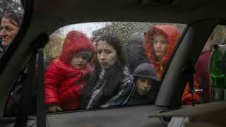 Жители Херсона выстраиваются в очередь под дождем у центра раздачи помощи 