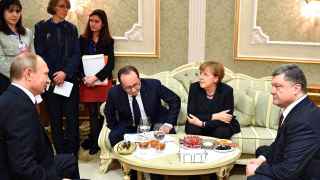Владимир Путин (слева) зловеще улыбается : коллективный Запад (президент Франции Франсуа Оланд и канцлерина ФРГ Ангела Меркель) помог ему уломать Петра Порошенко (справа)